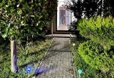a garden with a stone path leading to a door at 3 Bedroom Apartment with pool in Čeluga