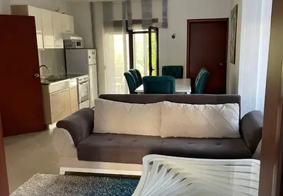 a living room with a couch and a kitchen at 3 Bedroom Apartment with pool in Čeluga