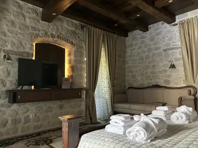 a room with a bed and a television and towels at KAŽIN supreme in Kotor