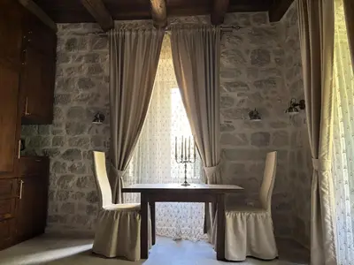 a dining room with a table and chairs and a window at KAŽIN supreme in Kotor