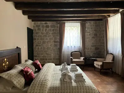 a bedroom with a bed and a chair and a window at KAŽIN supreme in Kotor