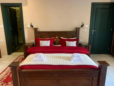 a bedroom with a large wooden bed with red pillows at KAŽIN supreme in Kotor