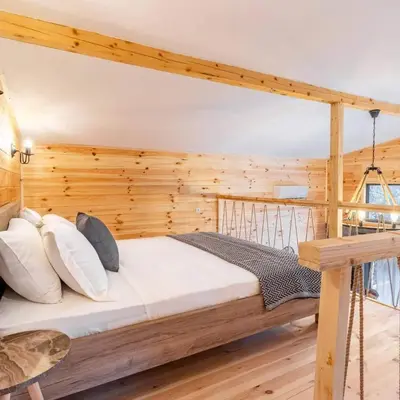 a bed in a room with a wooden wall at Olive Treasure in Ulcinj