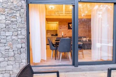 a dining room and kitchen with sliding glass doors at Olive Treasure in Ulcinj