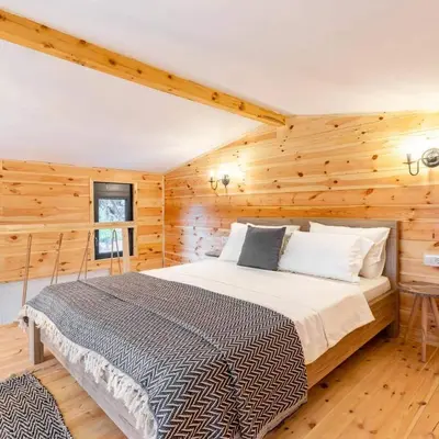 a bedroom with a bed in a room with wooden walls at Olive Treasure in Ulcinj