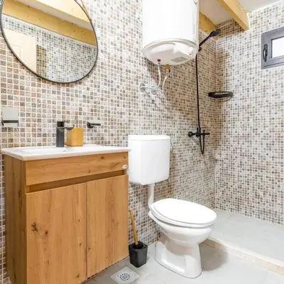 a bathroom with a toilet and a sink and a mirror at Olive Treasure in Ulcinj