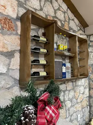 a wall with a shelf with wine bottles at Cosy Cottage with Private Pool - Andrej in Danilovgrad