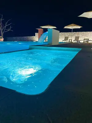 a swimming pool at night with a blue pool at Cosy Cottage with Private Pool - Andrej in Danilovgrad