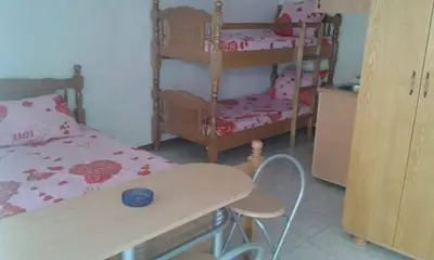 a bedroom with two bunk beds and a table and chairs at Bojana Blue Retreat in Ulcinj