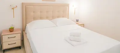 a bedroom with a large white bed and two night stands at Mar nero Apartments in Bregvija