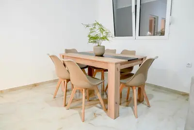 a wooden table with chairs and a potted plant on it at Mar nero Apartments in Bregvija