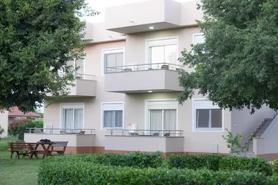 a white building with two balconies and two tables at Mar nero Apartments in Bregvija