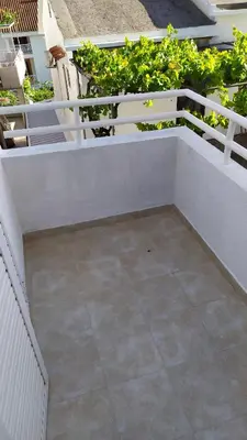 a patio with a white fence and some plants at FLAT FOR RENT MARINOVIC in Budva