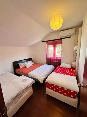a room with three beds with red and white sheets at House of peace in Podgorica