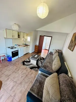 a living room with a couch and a kitchen at House of peace in Podgorica