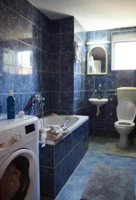 a bathroom with a washing machine and a toilet at House of peace in Podgorica