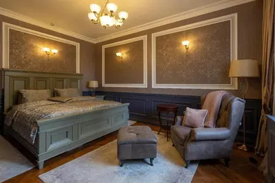 a bedroom with a bed and a chair and a chandelier at Downtown Residence in Podgorica