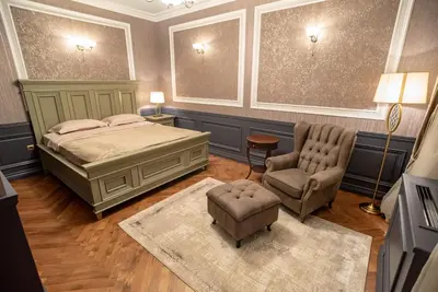 a bedroom with a bed and a chair at Downtown Residence in Podgorica