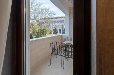 a balcony with a table and chairs and a window at Downtown Residence in Podgorica