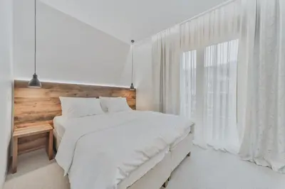 a bedroom with a white bed and a large window at Hotel Vladimir in Budva
