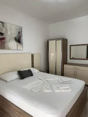 a bedroom with a large white bed with a mirror at Apartments Amar in Ulcinj