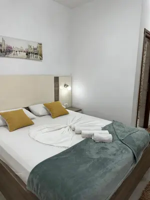 a large white bed with two towels on it at Apartments Amar in Ulcinj