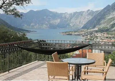 a table and chairs on a balcony with a view of a lake at 3-Bedroom Apartment With Panoramic Bay Views in Kotor