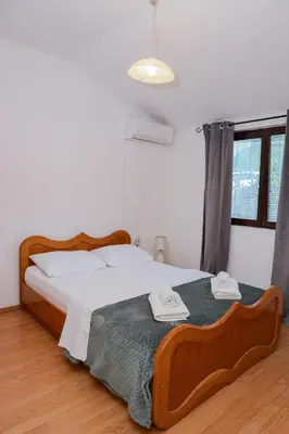 a bedroom with a large bed with two towels on it at 3-Bedroom Apartment With Panoramic Bay Views in Kotor