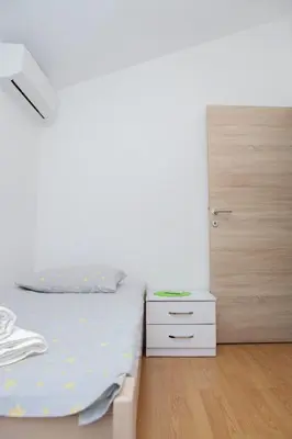 a white bedroom with a bed and a dresser at 3-Bedroom Apartment With Panoramic Bay Views in Kotor