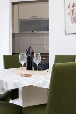a table with two glasses and a bottle of wine at 3-Bedroom Apartment With Panoramic Bay Views in Kotor