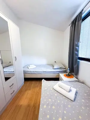 a small room with two beds and a mirror at 3-Bedroom Apartment With Panoramic Bay Views in Kotor