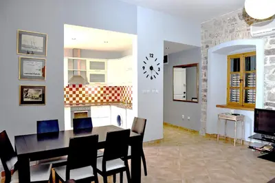 a dining room and kitchen with a table and chairs at Cozy 2 Bedroom Apartment in Antique Bizanti Palace in Kotor