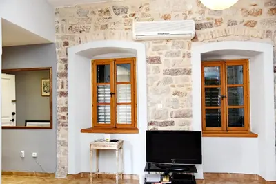 a living room with a tv and two windows at Cozy 2 Bedroom Apartment in Antique Bizanti Palace in Kotor