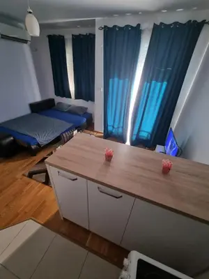 a living room with two beds and a table at Adrianna apartment City kvart in Podgorica