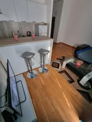 a living room with two stools and a table at Adrianna apartment City kvart in Podgorica
