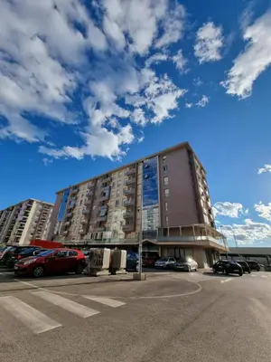 a large building with cars parked in a parking lot at Adrianna apartment City kvart in Podgorica