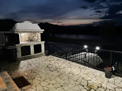 a gazebo sitting on top of a balcony at night at Lotos Luxury House - Skadar Lake in Virpazar