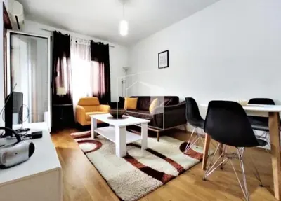 a white living room with a table and chairs at Flat Iva in Podgorica