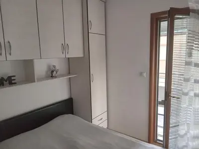 a room with white cabinets and a bed and a window at Flat Iva in Podgorica