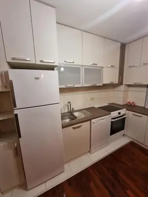 a white kitchen with a sink and a refrigerator at 5 star apartment in Podgorica