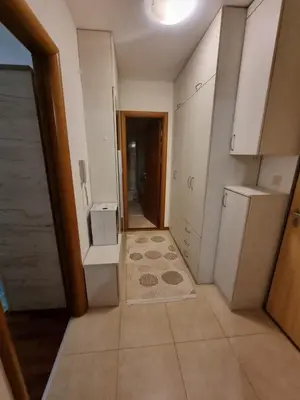 a kitchen with white cabinets and a door to a hallway at 5 star apartment in Podgorica