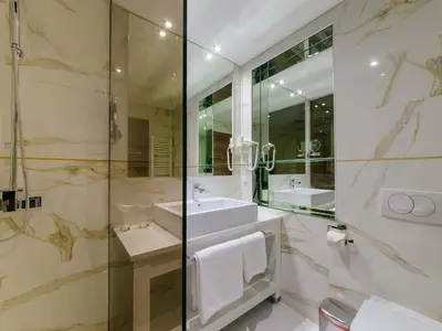 a bathroom with two sinks and a glass shower at Hotel New Star in Podgorica