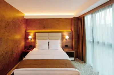 a hotel room with a large bed and a window at Hotel New Star in Podgorica