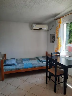 a bedroom with a bed and a table and a desk at Милый гостевой апартамент in Bar