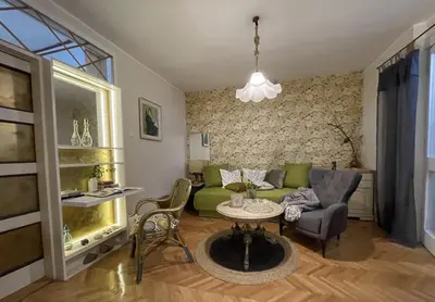 a living room with a green couch and a table at Apartment Navigator's lodging in Kotor