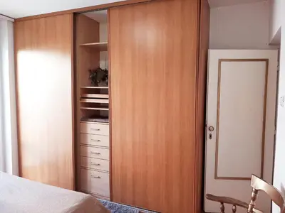 a bedroom with a closet with a wooden door at Apartment Navigator's lodging in Kotor