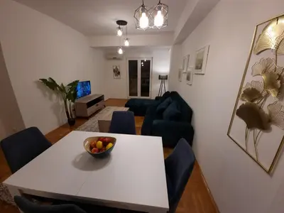 a living room with a white table and blue chairs at Big apartment in Podgorica