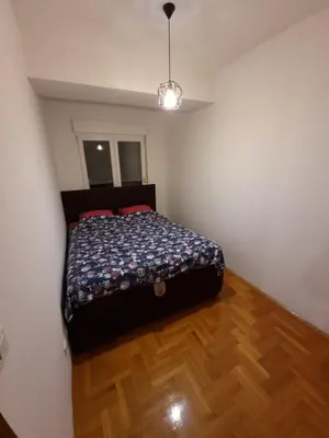 a bedroom with a bed in the corner of a room at Big apartment in Podgorica