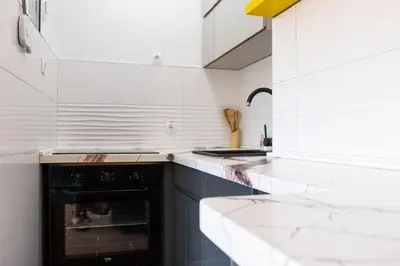a kitchen with white walls and a black oven at Campi d’Oro in Kotor