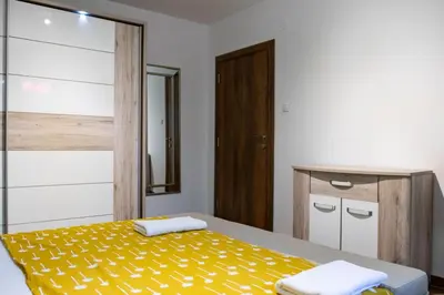 a bedroom with a bed with a yellow blanket at Campi d’Oro in Kotor